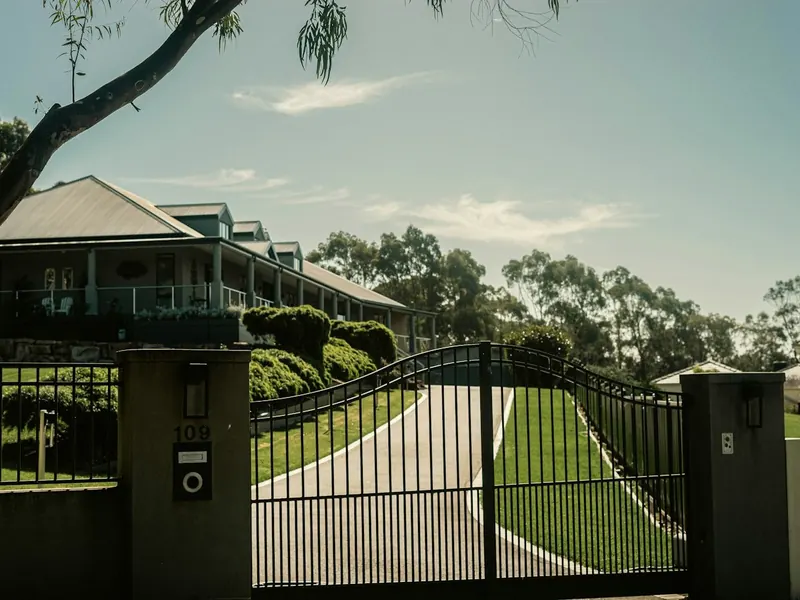 Automated steel driveway gate with rendered pillars
