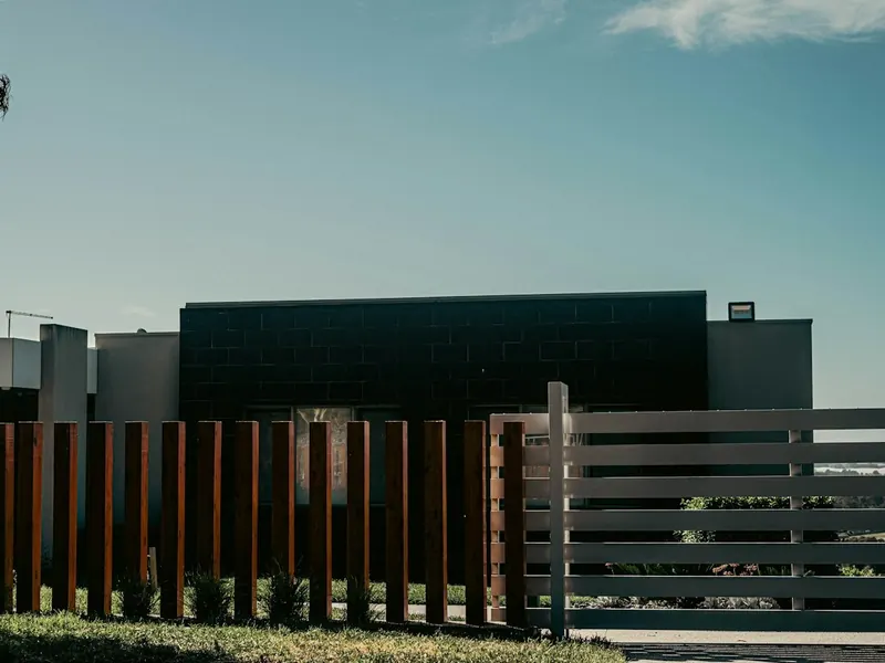 Contemporary fence with vertical timber posts and slats