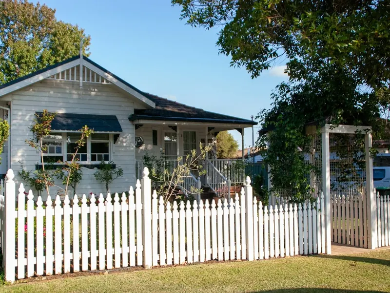 White picket fence and gate at a weatherboard home